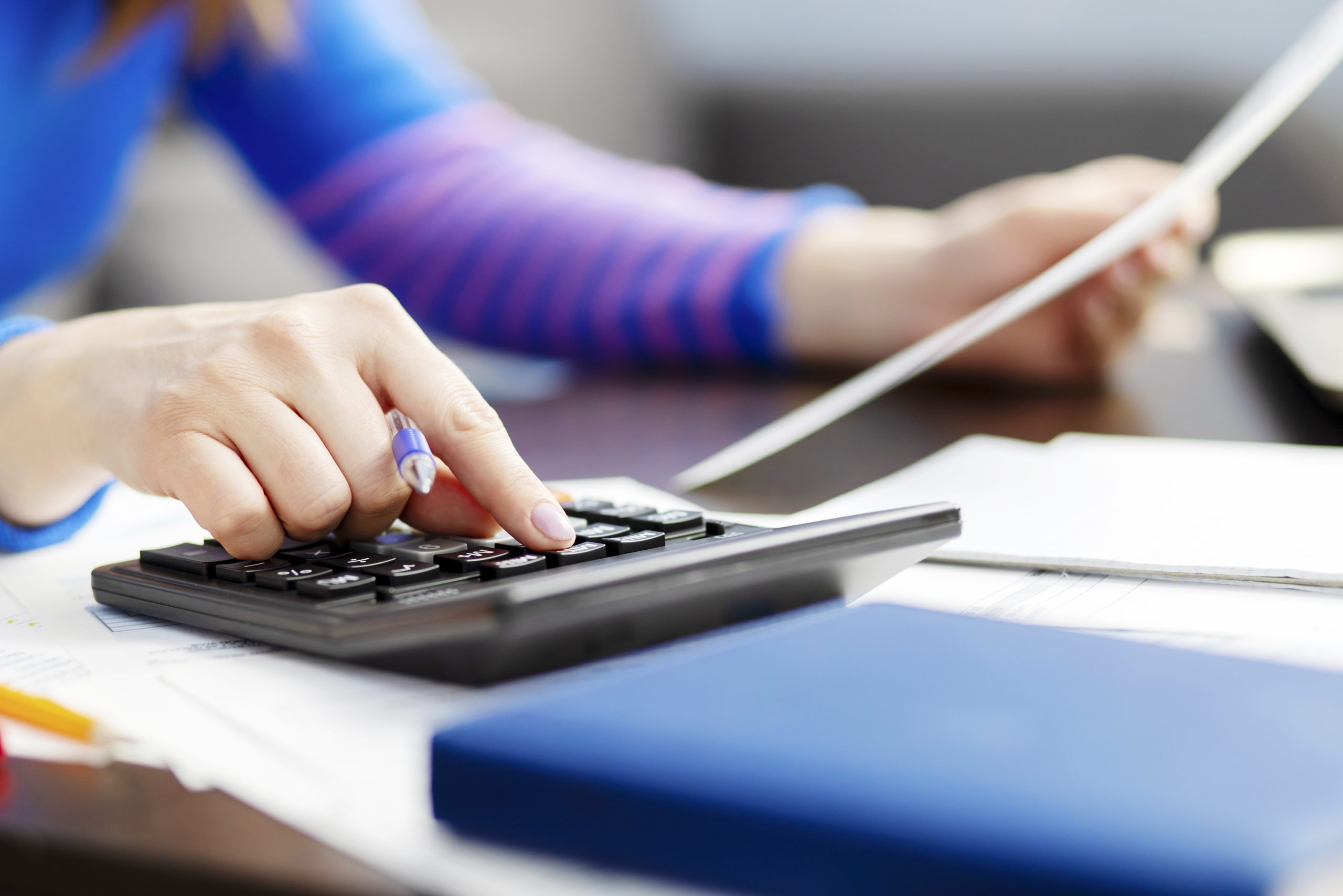 Woman using calculator for calculate domestic bills at home, doing paperwork
