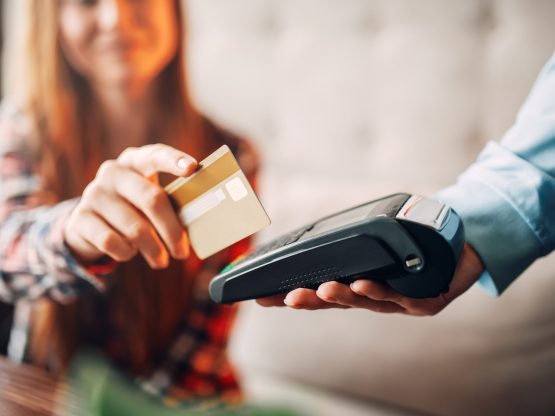 Young woman paying with credit card in cafe